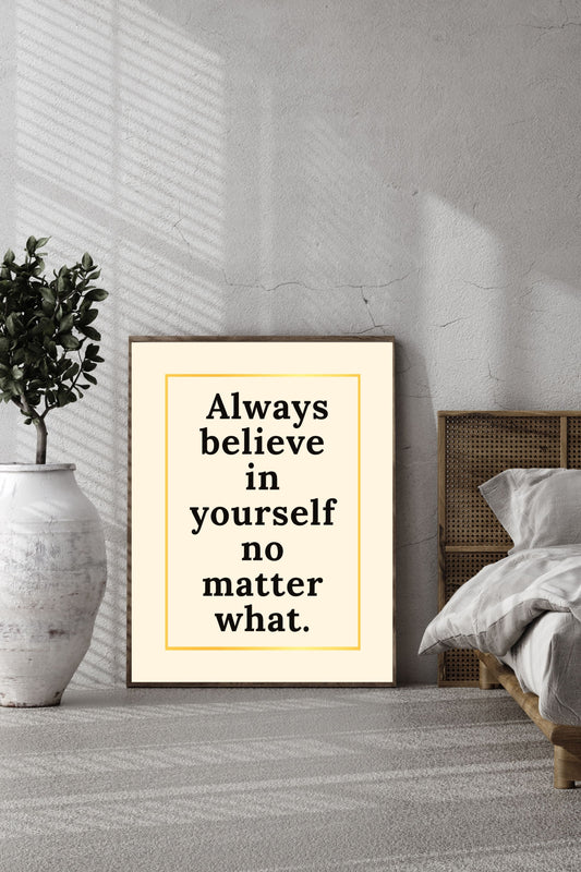 Minimalist printable wall art featuring the quote "Always believe in yourself no matter what" in black typography inside a gold border, styled in a modern, sunlit bedroom scene.